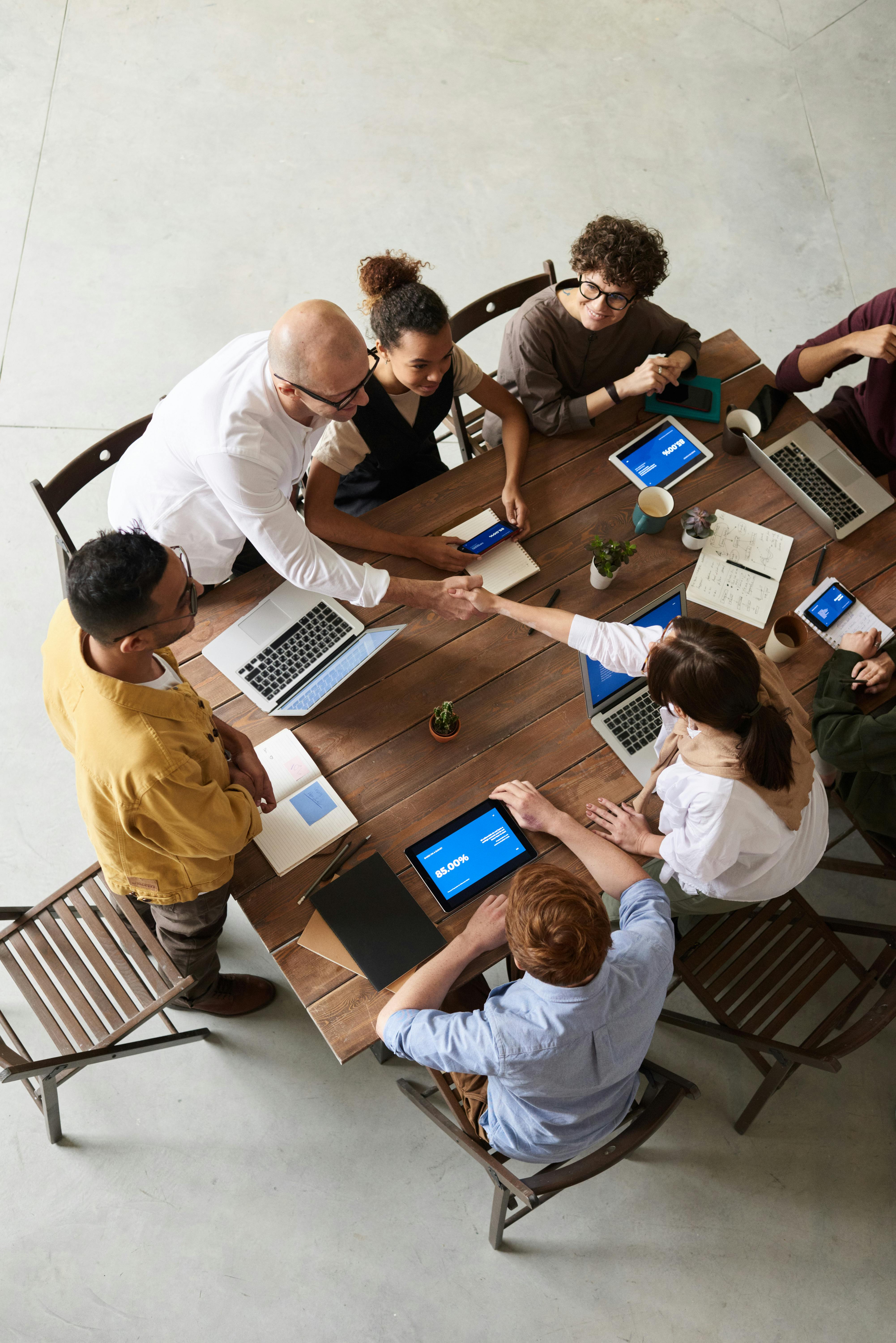 people sitting around office table with laptop doing the work related to projects
